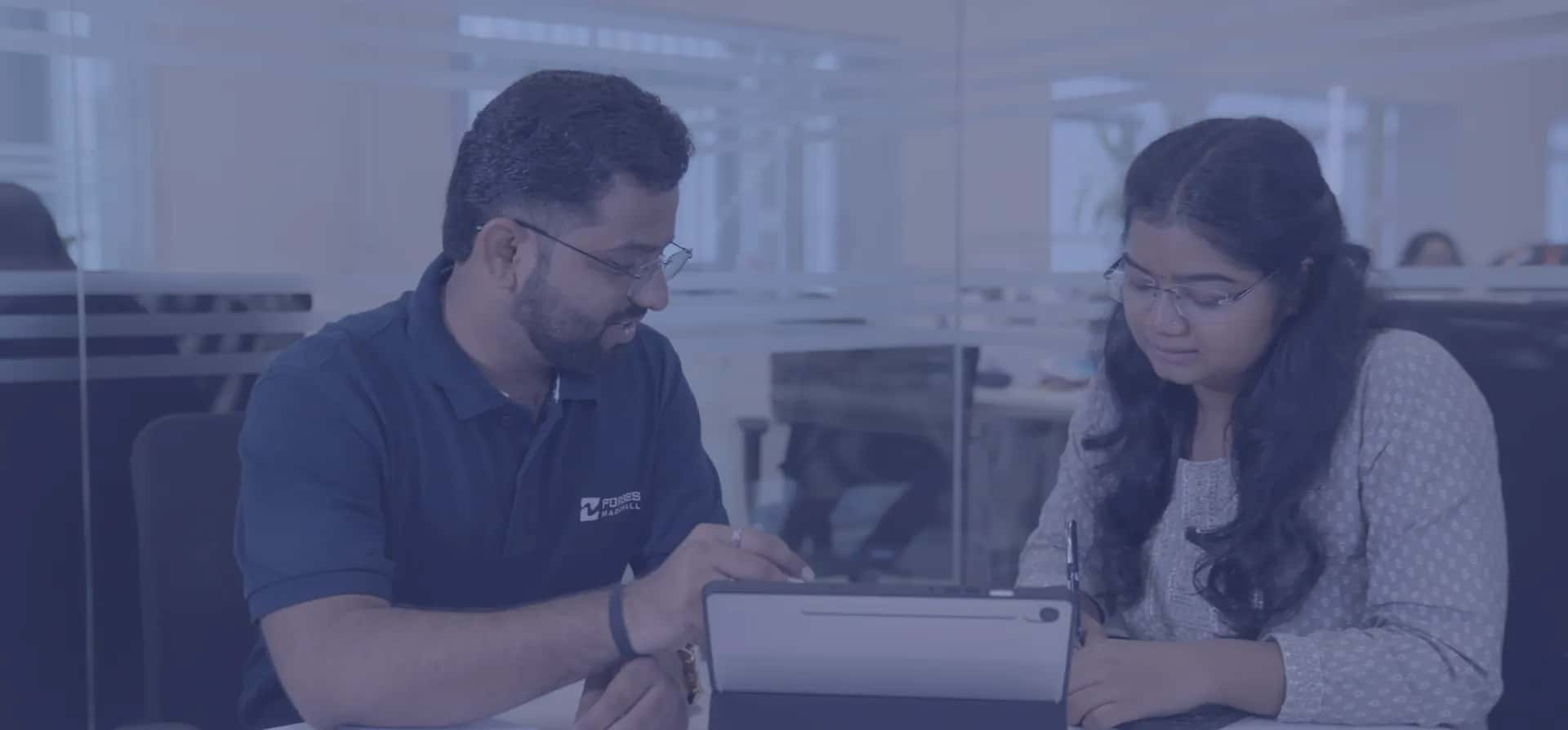 Forbes Marshall team members reviewing work on a tablet