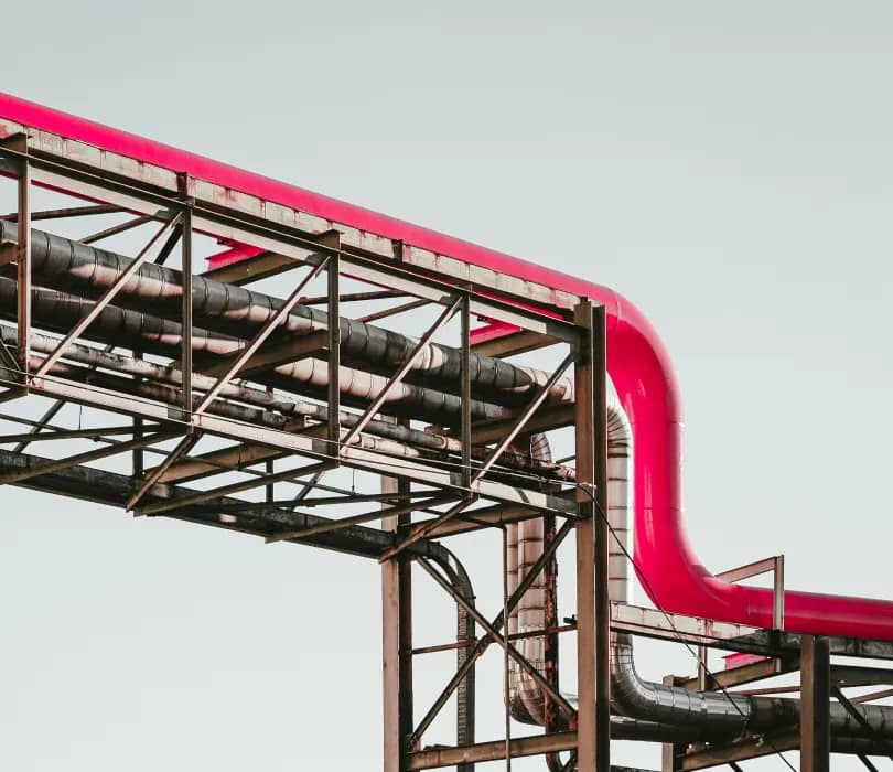 Industrial pipe rack with a red elbow pipe on a steel support