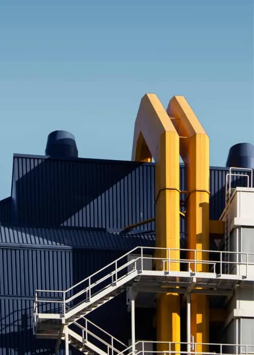 Industrial building exterior with yellow vents and a metal staircase
