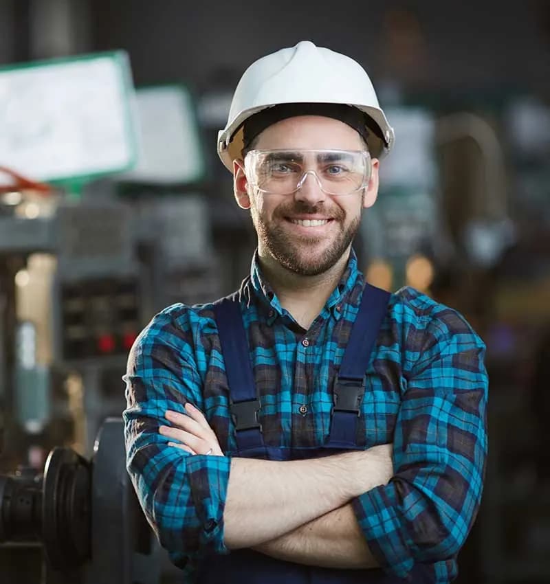 Smiling engineer in a hard hat on site