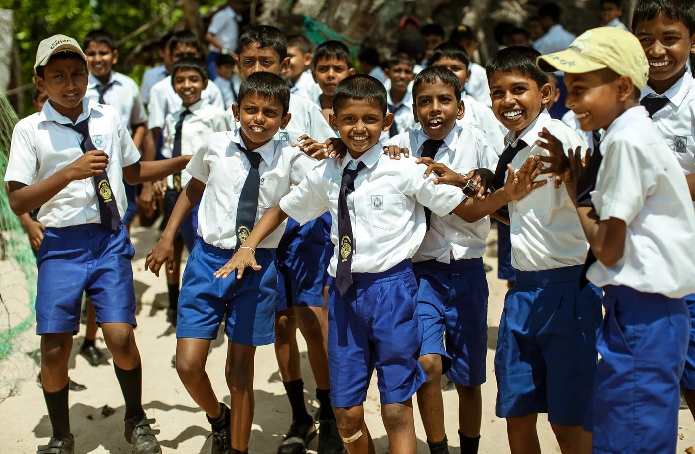 School children in uniform smiling and waving