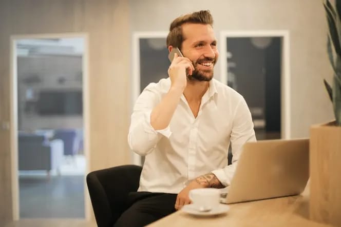 Professional on a phone call at a desk with a laptop