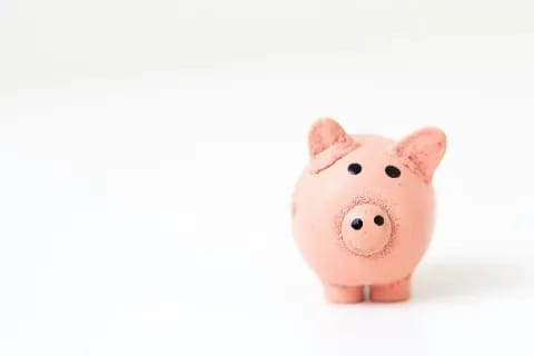 Pink piggy bank on a white surface