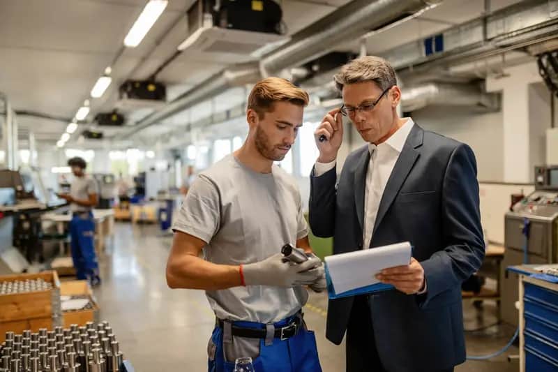 Engineers cooperating while analyzing reports in a factory